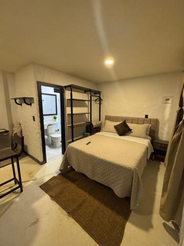 a bedroom with a large bed and a bathroom at La Aldea in Mocoa