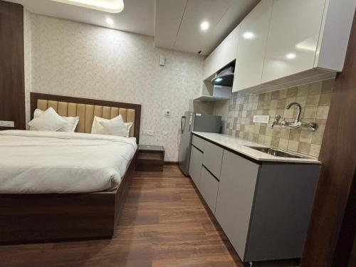 Un dormitorio con una cama y una cocina con fregadero. en QuickIn Stayz managed by The AIKaya Hotels, en Gurgaon
