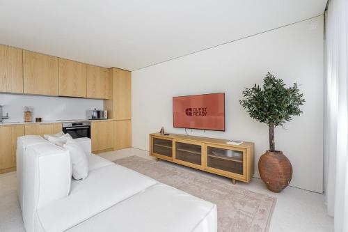 Una sala de estar con un sofá blanco y un televisor. en GuestReady - DPV GuestHouse - Apart 6, en Oporto
