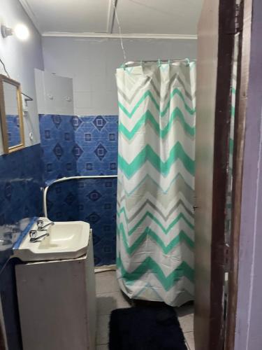 a bathroom with a shower curtain and a sink at Residencial Saez in Viña del Mar