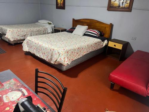 a room with two beds and a table and a chair at Residencial Saez in Viña del Mar