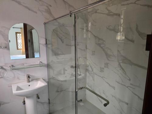 a bathroom with a glass shower and a sink at Lakeside Hilltop Haven -3 Bedroom House in Katamanso