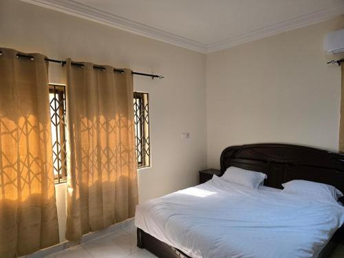 a bedroom with a bed and two windows at Lakeside Hilltop Haven -3 Bedroom House in Katamanso