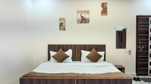 une chambre avec un lit avec une tête de lit en bois dans l'établissement LD Guest House, Ayodhya, à Ayodhya