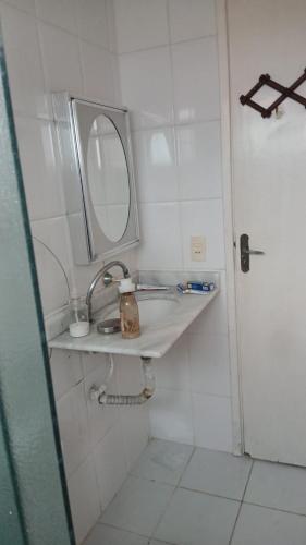a bathroom with a sink and a mirror at Apartamento coneglian in Itanhaém