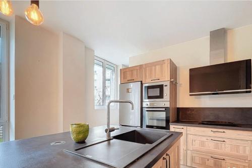 a kitchen with a sink and a microwave at Stunning 230m with garden in the city center in Caen
