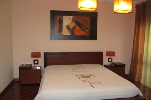 1 dormitorio con 1 cama y una pintura en la pared en Apartamento Superior Helena's Porto Corner, en Vila Nova de Gaia