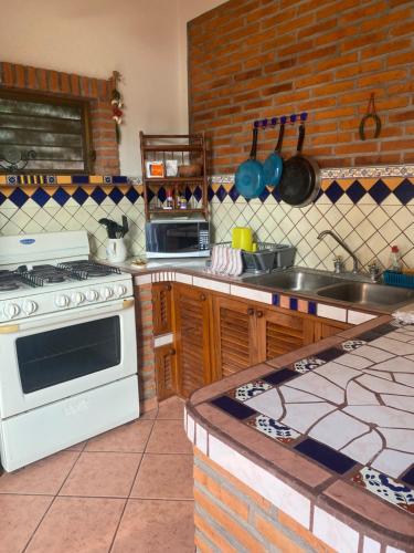 eine Küche mit Herd und Spüle in der Unterkunft Casitas Las Palmas - La Brisa in Punta Mita