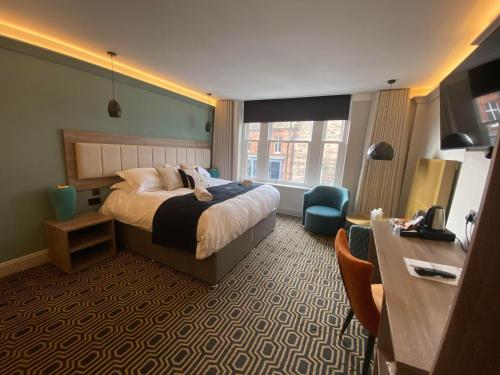 a hotel room with a bed and a desk at The George Hotel in Penrith