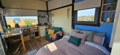 a bedroom with a bed and a kitchen with windows at Casita en un lugar de encanto in Las Grutas