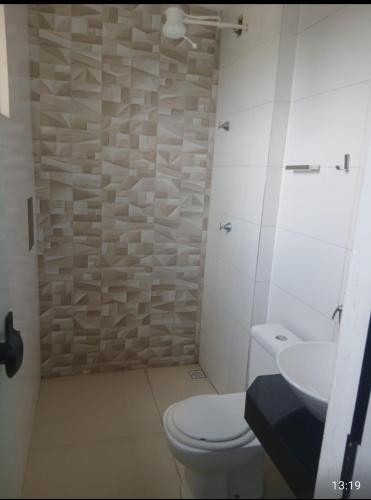 a bathroom with a toilet and a sink at Hotel Rio do Ouro in Porangatu