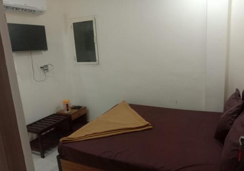 a small bedroom with a bed and a table at Hotel Kalaptaru in Nainital