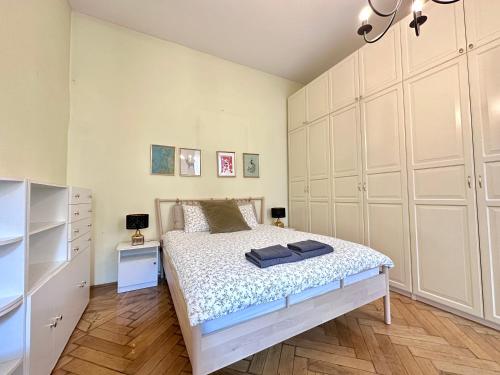 una camera da letto con un letto con armadi bianchi di 布达佩斯市中心西火车站公寓 a Budapest