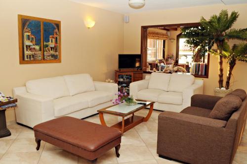 a living room with two couches and a coffee table at Hotel Athena in Kokkari
