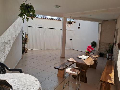 een patio met houten tafels en stoelen in een gebouw bij Casa BH Arcondicionado todos quartos e garagem in Belo Horizonte