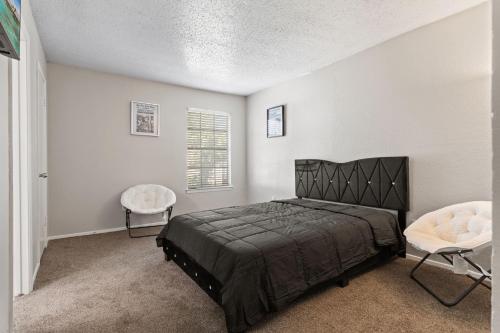 アーリントンにあるComfy 2Bdr Unitのベッドルーム(黒いベッド1台、椅子付)