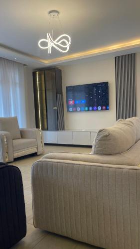 a living room with a large couch and a tv at Eric Wilkins villas in Kampala