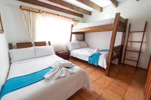 a bedroom with two bunk beds and a window at Apartamento Madeiro in Villa de Leyva
