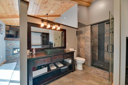 a bathroom with a sink and a toilet and a mirror at Spacious Canandaigua Group Getaway House and Barn! in Honeoye