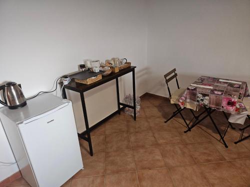 a kitchen with a table and a small refrigerator at podere dell'ovo in Gabbro