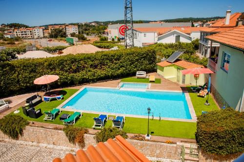 an overhead view of a swimming pool with chairs and umbrellas at Hotel Larverde in Sertã