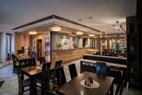 a restaurant with tables and chairs and a bar at Apartmánový dom Fatrapark 1 s Wellness - Hlavná recepcia in Ružomberok