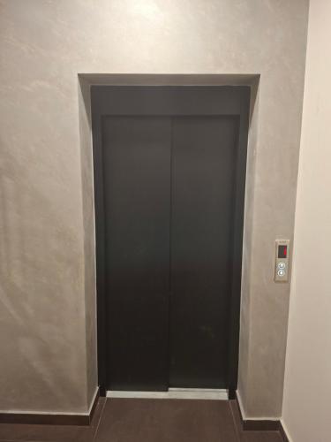 a hallway with a black door in a building at Apartman REINA in Prijedor