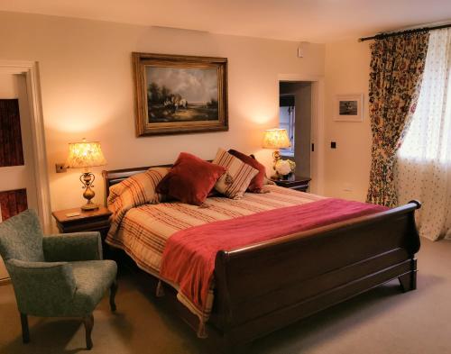 Un dormitorio con una cama grande y una silla. en Kilmokea Country Manor & Gardens, en New Ross