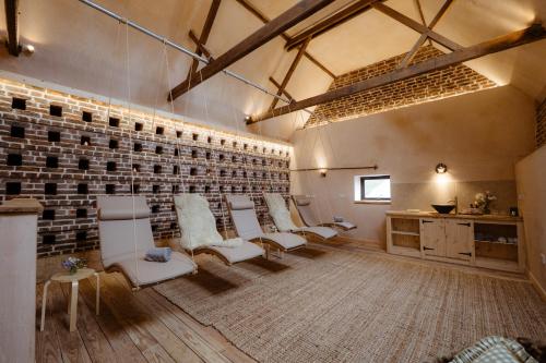 einen Salon mit weißen Stühlen und einer Ziegelwand in der Unterkunft Giant Yurt Sleeping 8 with Spa, Catering, Walled Gardens, Nature Reserve, Free Parking in Scunthorpe