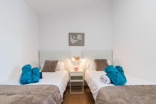Un dormitorio con dos camas con almohadas azules. en El Refugio de Agueda, en San Bartolomé