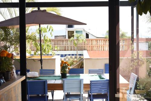 a table with chairs and an umbrella on a patio at El Diablo y La Luna B&B by El Diablo y La Sandia in Oaxaca City