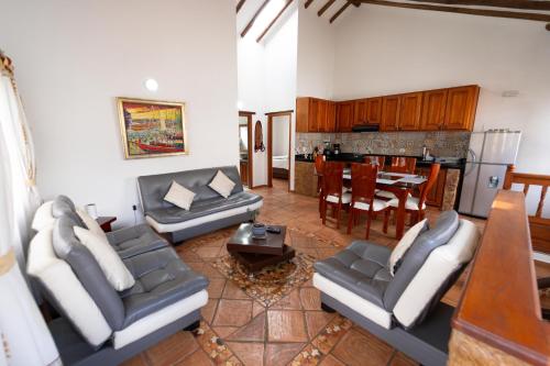 ein Wohnzimmer mit Sofas und einem Tisch sowie eine Küche in der Unterkunft BALCON DE CHIE in Villa de Leyva