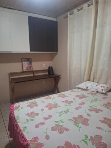 um quarto com uma cama com um edredão florido em Casa Sobrado em Cuiabá