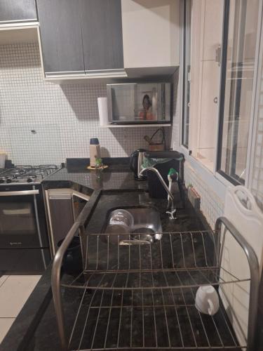 uma cozinha com um lavatório e um suporte para pratos em Casa Sobrado em Cuiabá