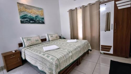 a bedroom with a bed with two towels on it at Gypsy Walker Plus in Varkala