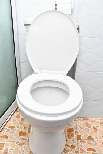a white toilet in a bathroom with a tile floor at Luxe-homestay 1 Bed Executive Studio in Eldoret