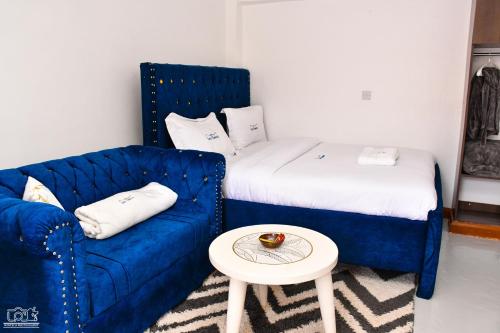 a room with a blue couch and a small table at Luxe-homestay 1 Bed Executive Studio in Eldoret