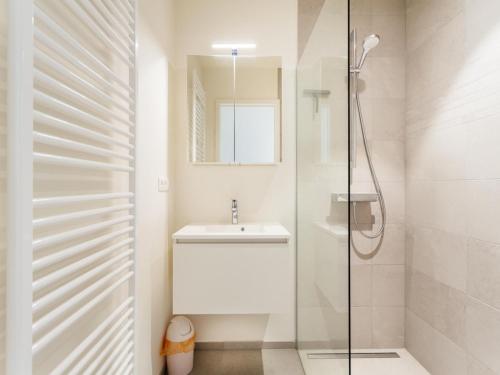 a white bathroom with a sink and a shower at LaVue premier in Galopen