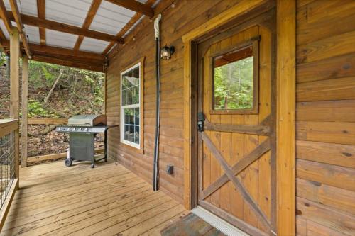 RogersにあるHot Tub & WiFi - Clifftop Cabin - Muir Valleyのドアとグリル付きの木造キャビン