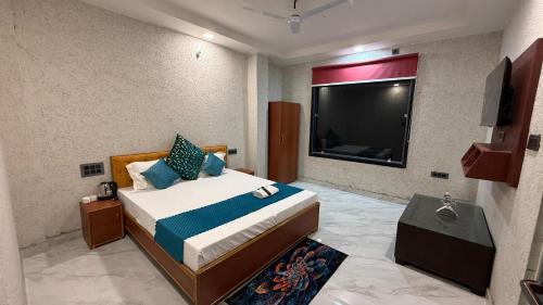 a bedroom with a bed and a flat screen tv at Bundeli Farm Resort & Banquet Orchha in Orchha