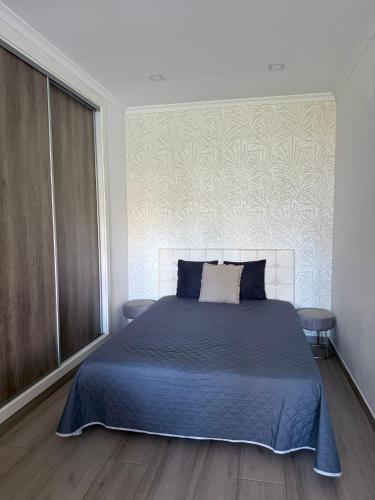 een slaapkamer met een groot bed met een blauwe deken bij Apartamento Machadinho in Vale de Pedras