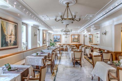 um restaurante com mesas e cadeiras e um lustre em Tmark Hotel Vaticano em Roma