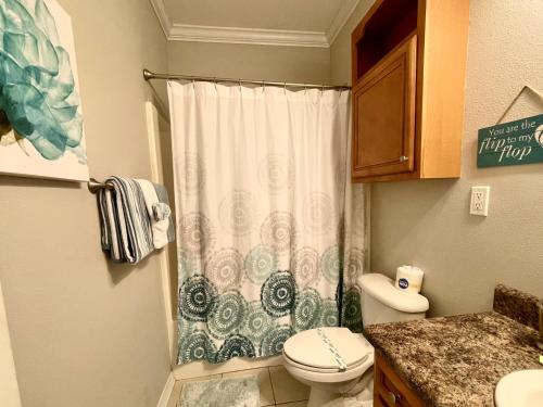 a bathroom with a toilet and a shower curtain at 148 Beau Clair - Beachside Townhome with Pool in Long Beach in Long Beach