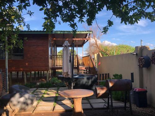 a patio with a table and chairs in front of a house at Romantic cabin in Big 5 Reserve in Dinokeng Game Reserve