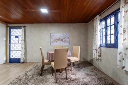uma sala de jantar com mesa e cadeiras em Casa com Wi-Fi e garagem a 400m do Museu Imperial em Petrópolis