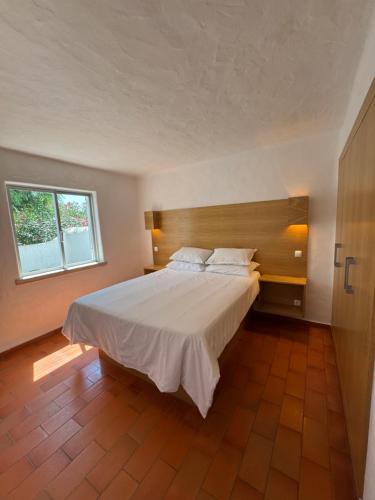 ein Schlafzimmer mit einem großen Bett und einem Fenster in der Unterkunft Villa Valentina in Carvoeiro