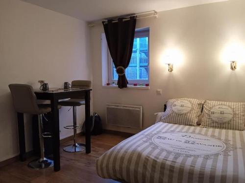 a bedroom with a bed and a desk and a window at Le briochin in Saint-Brieuc