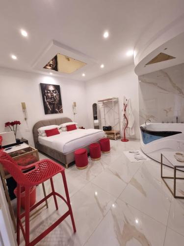 a large bedroom with a bed and red chairs at Room 84 in Poggiomarino