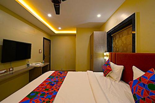 a bedroom with a large bed with a tv on the wall at Mio Boutique Hotel - Just Launched in Hyderabad