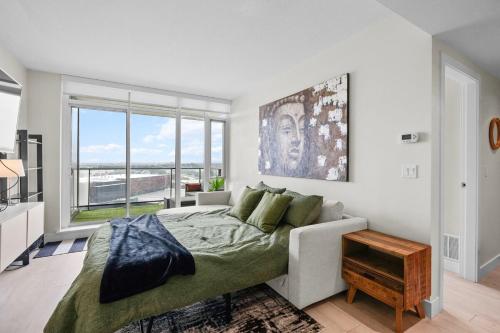 een slaapkamer met een bed en een groot raam bij Downtown Calgary Modern 1BR with Pullout couch in Calgary